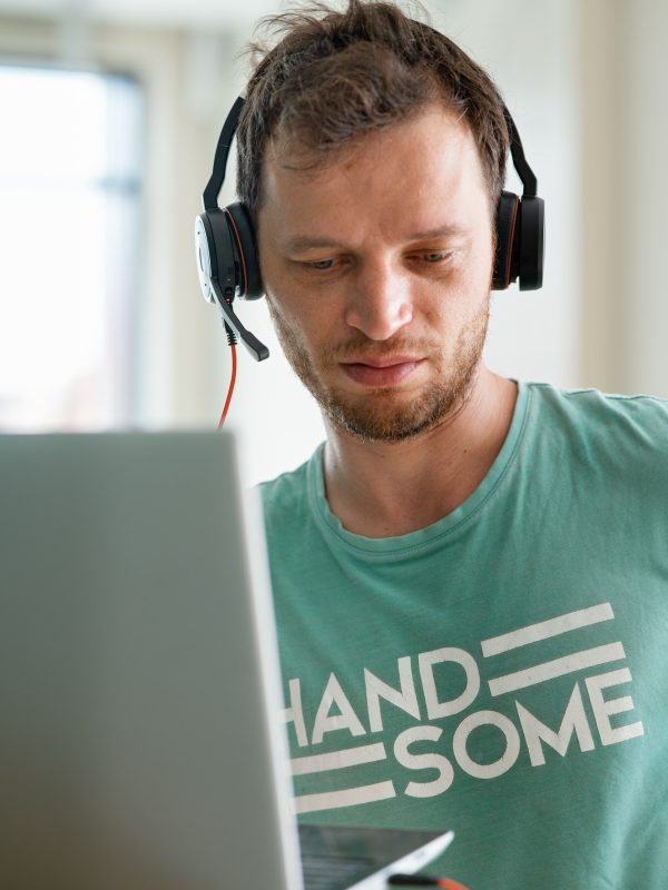 young-programmer-works-from-home-using-laptop-and-headphones.jpg